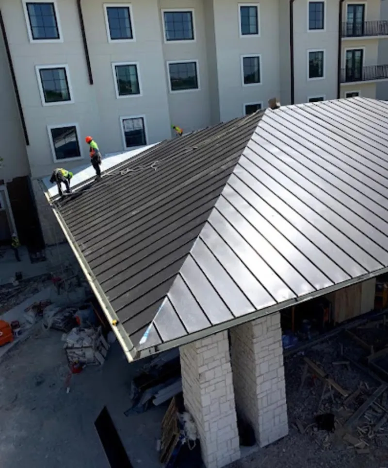 Crew installing standing seam metal roof panels on a commercial project in Oroville